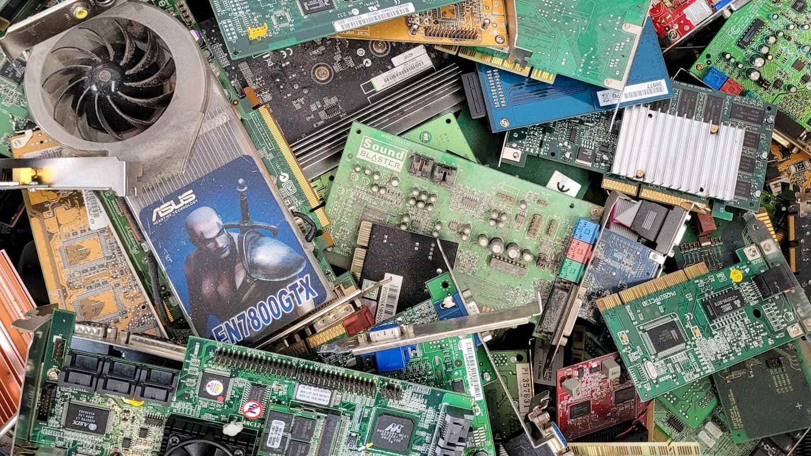 A dense pile of mixed circuit boards and electronic components