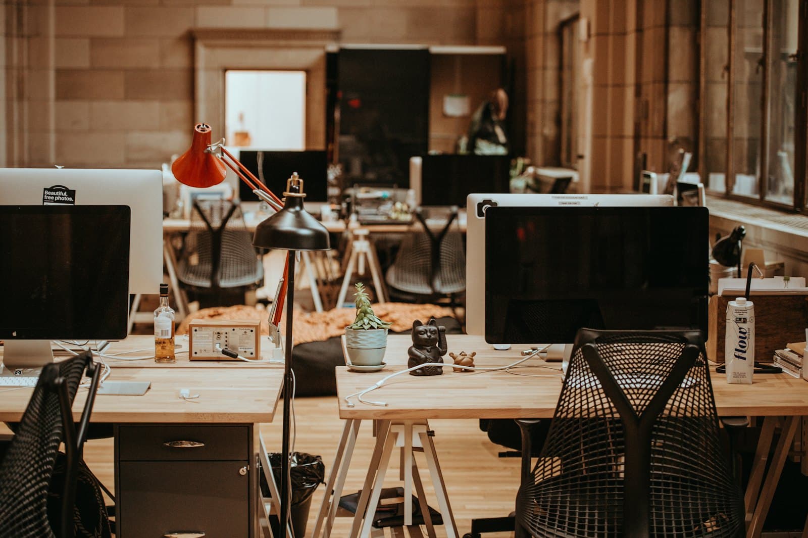 Switched off monitors on a row of empty office desks