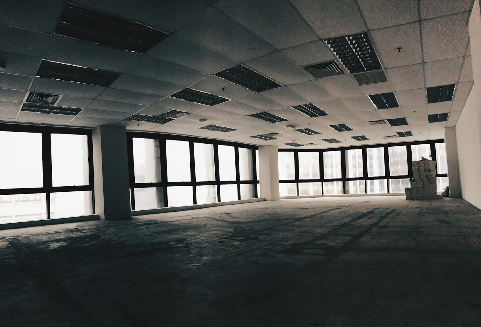 An emptied open plan office with bare floor and windows