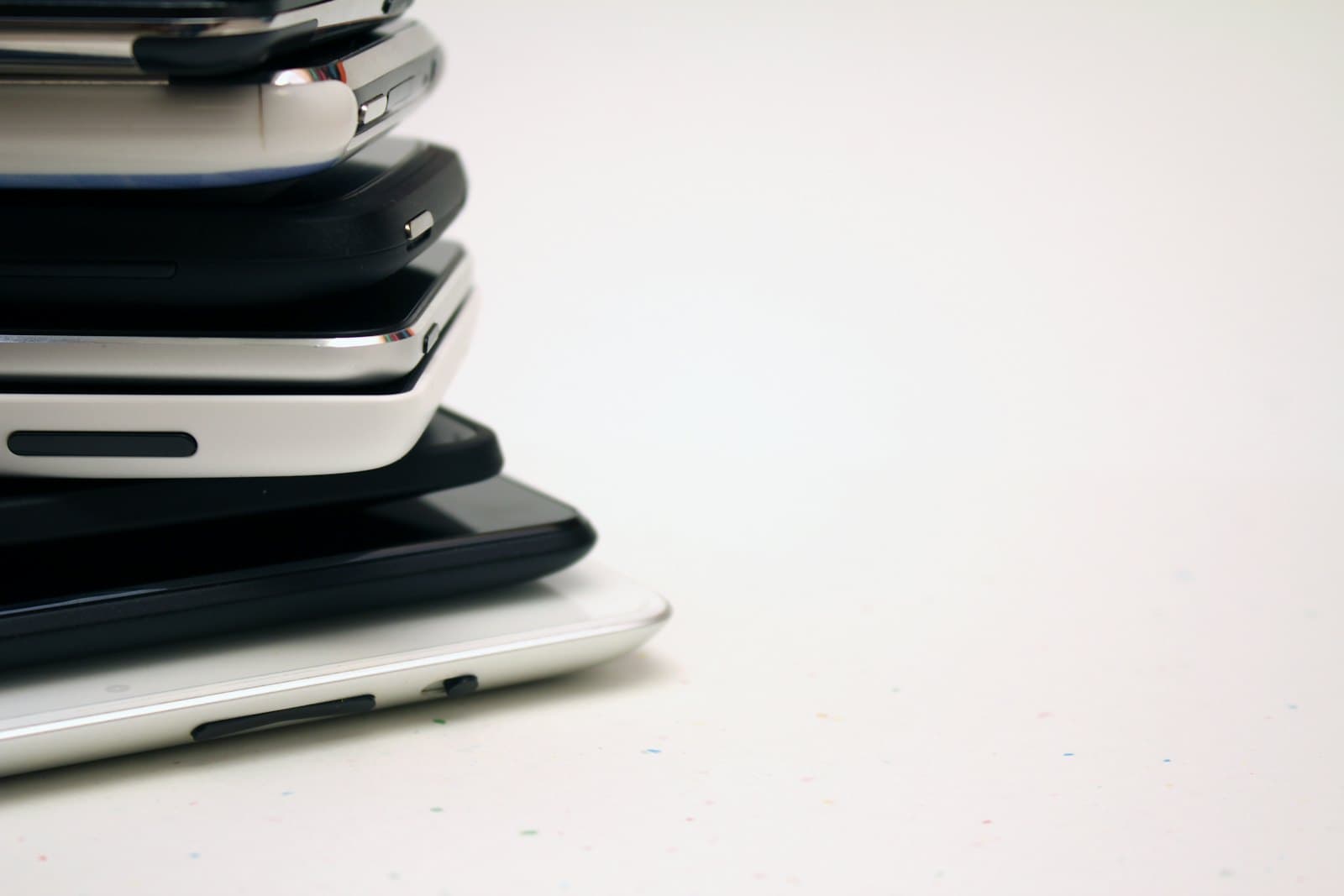 A stack of used smartphones piled on top of one another